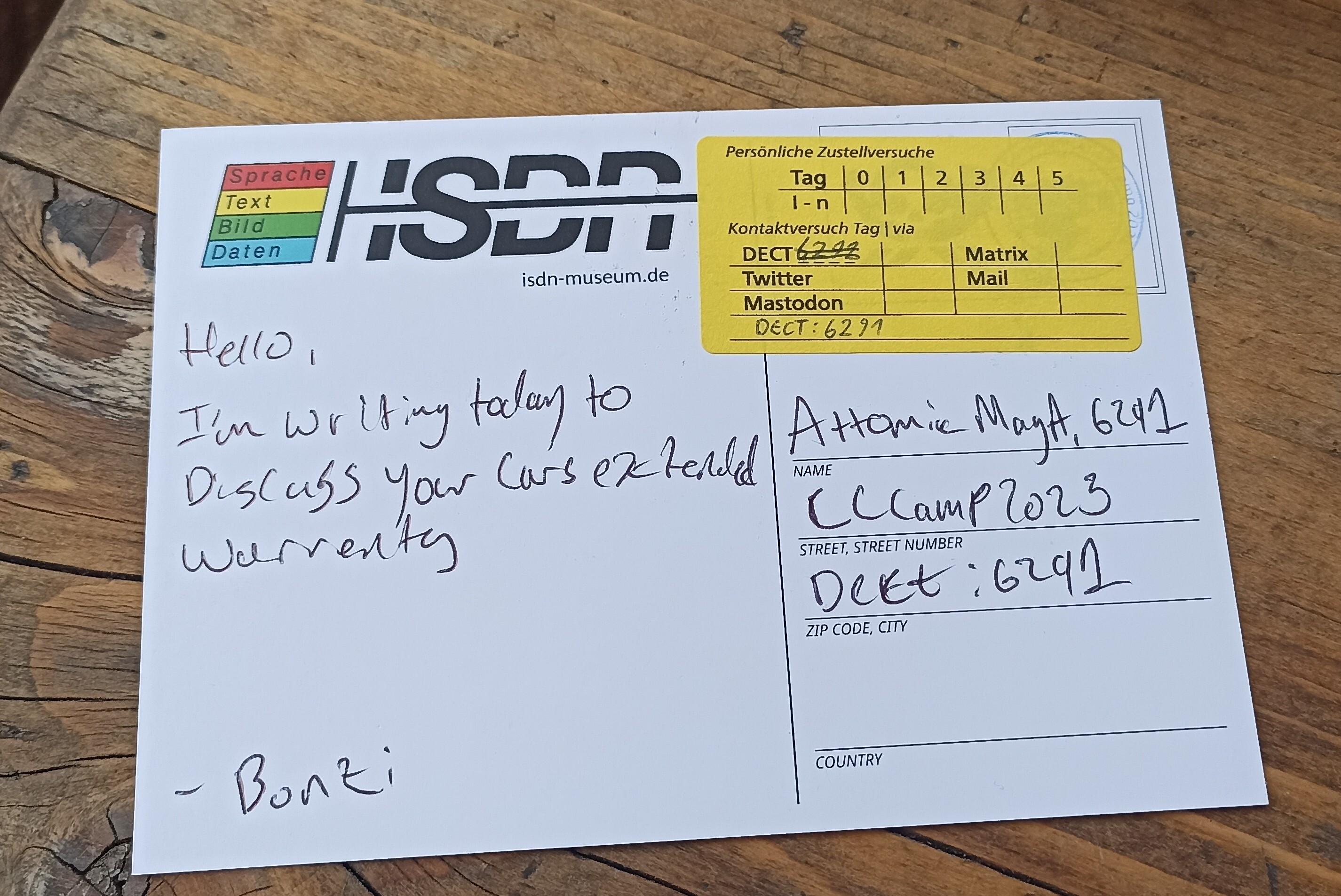 A postcard signed bonzi, saying 'Hello, I'm writing today to discuss your cars extended warranty'