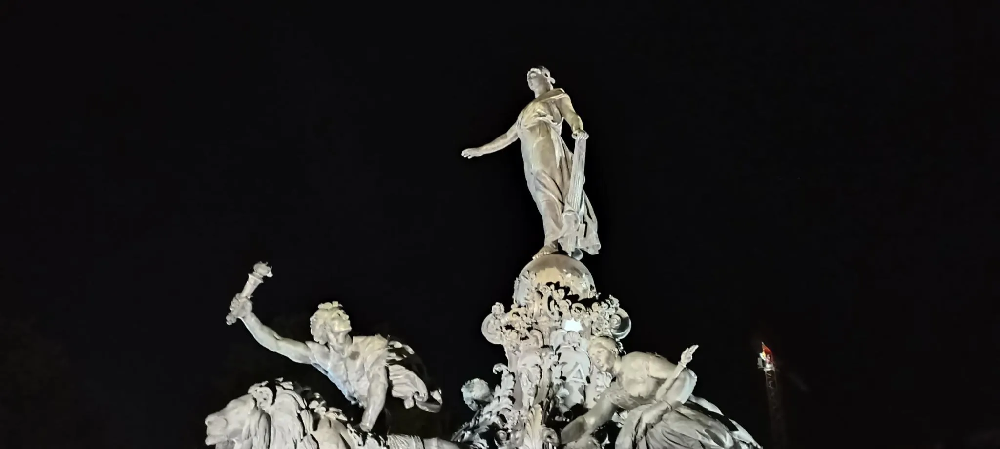 The statues on the Square of the Nation, illuminated, with the picture taken at night