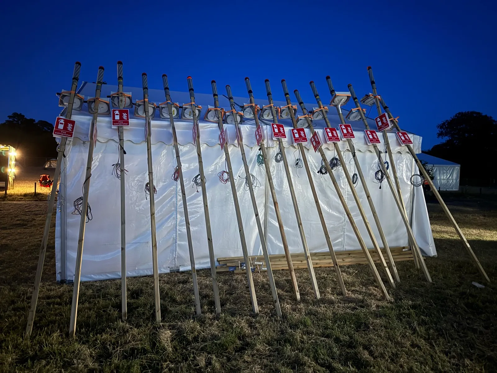 nighttime picture of 17 dk poles leaning against a tent.