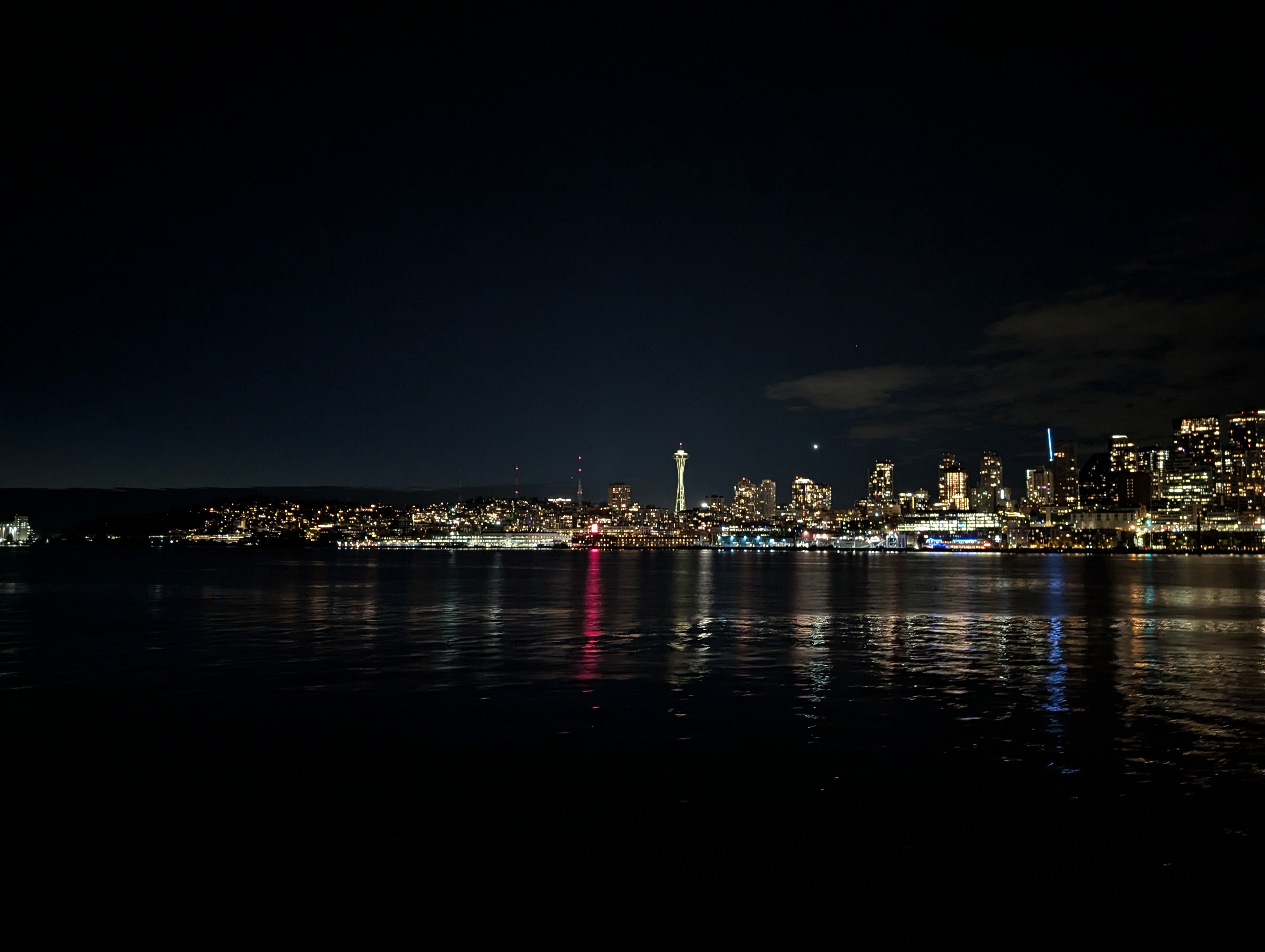 Picture of the Seattle skyline in the night, taken from a ferry.