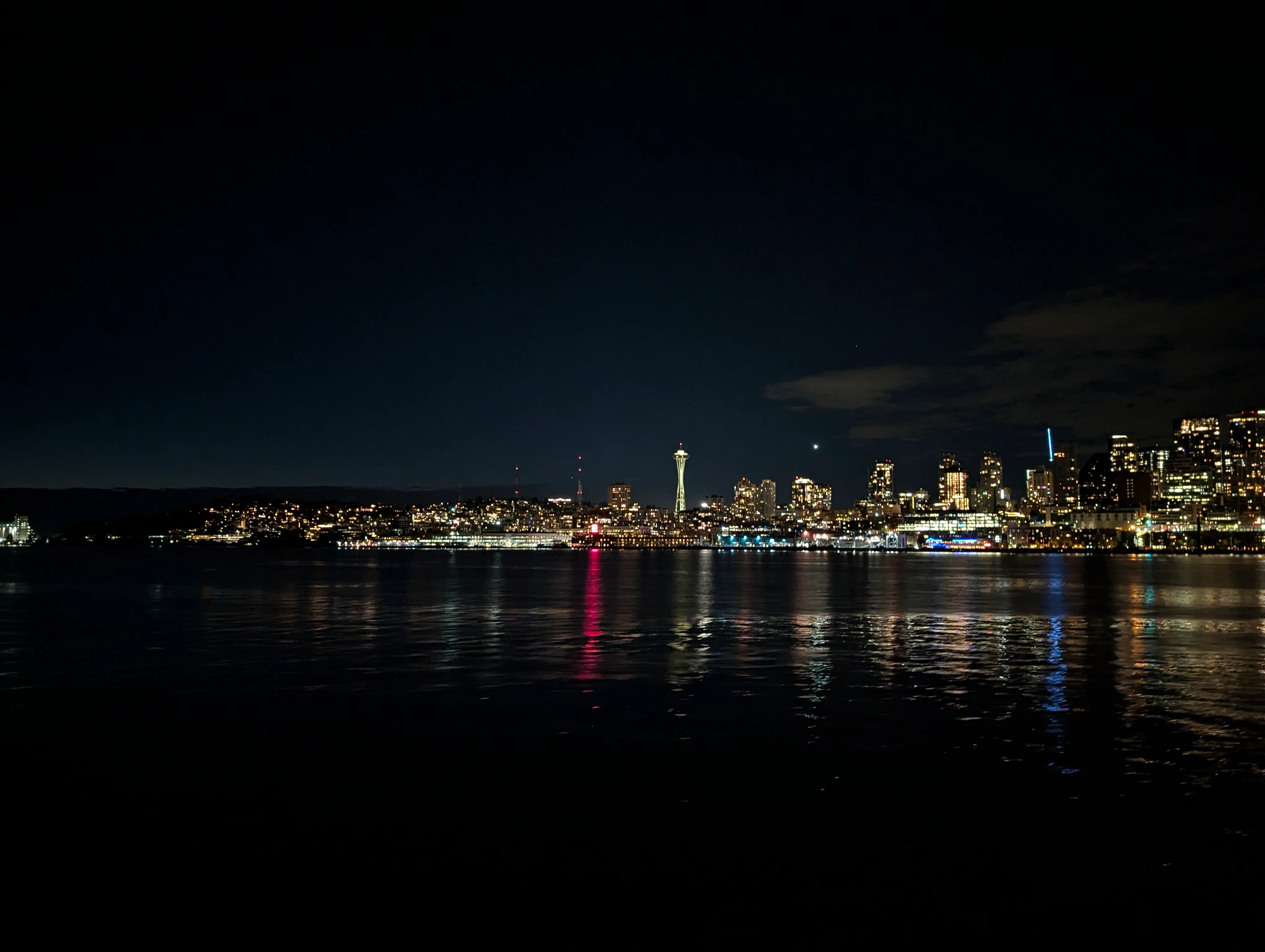 Picture of the Seattle skyline in the night, taken from a ferry