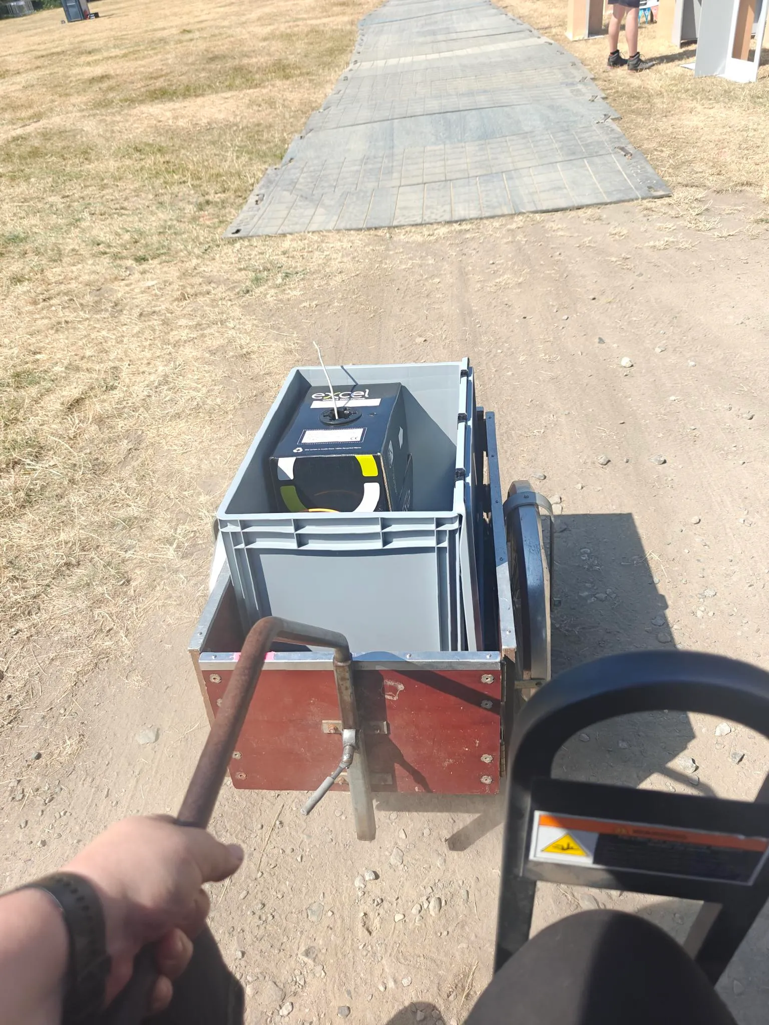 picture of a bike cart full of kit being held by me, sat in the passenger seat of a small taxi buggy.